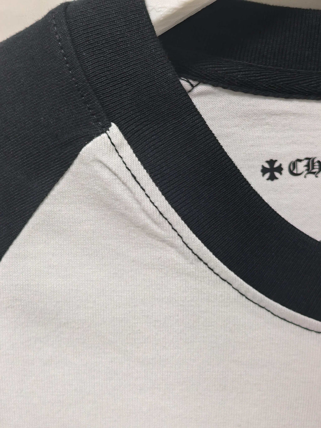 Black-and-white raglan long-sleeve T-shirt with contrast collar and small emblem