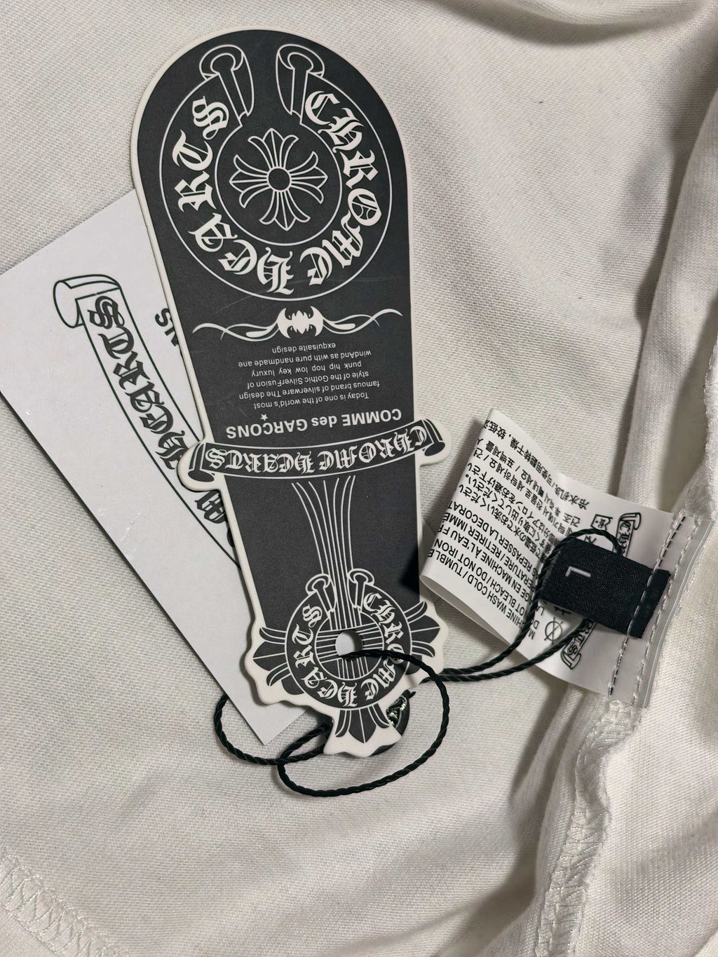 White long-sleeve T-shirt neck label and black size tag with string