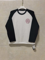 Raglan long-sleeve shirt with white body and black sleeves, maroon chest logo