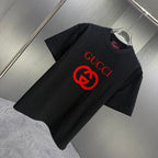 Black Gucci short-sleeve T-shirt with red Gucci logo, shown at an angle on a hanger