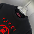 Black Gucci short-sleeve T-shirt neckline detail with red Gucci logo on the chest