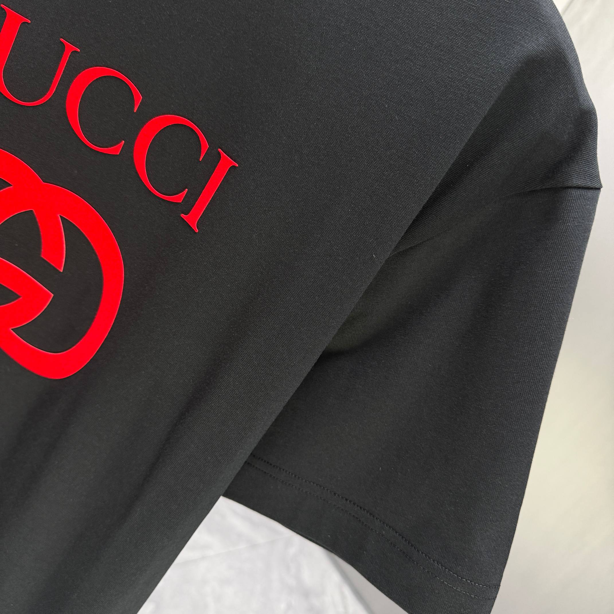 Black Gucci T-shirt sleeve and shoulder seam with red logo print detail