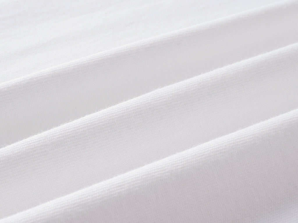 White knit fabric close-up with fine texture and smooth weave.