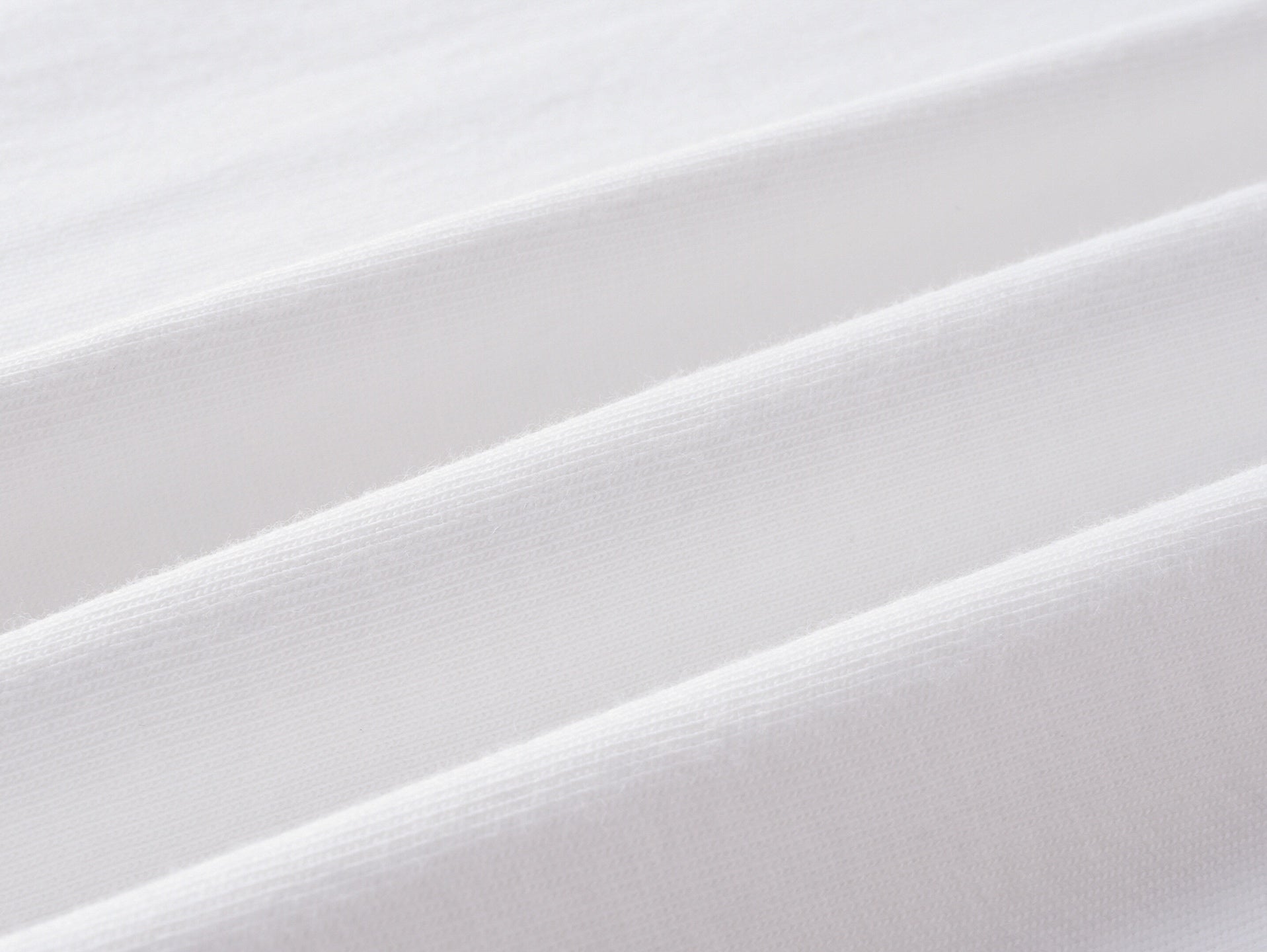White jersey knit fabric close-up with fine textured weave