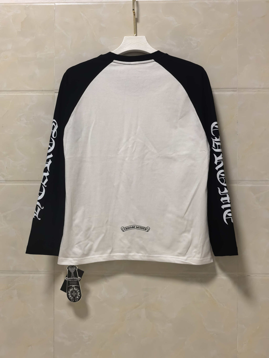 Back view raglan long-sleeve shirt, white body with black sleeves and small logo