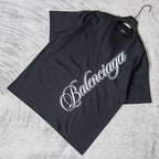 Balenciaga T-shirt in dark navy, flat lay, with white script logo on the front