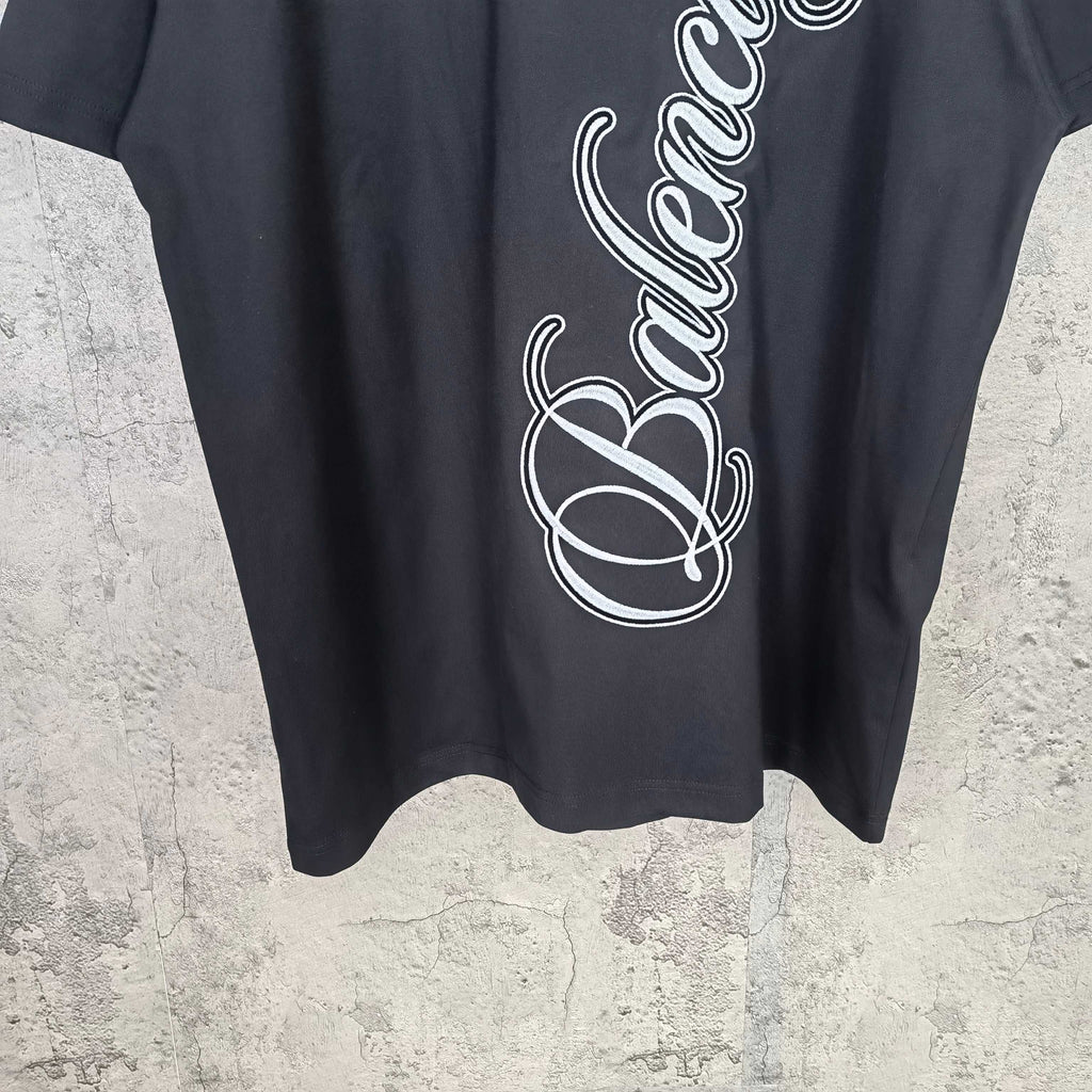 Balenciaga T-shirt front close-up with white script logo, crew neck visible
