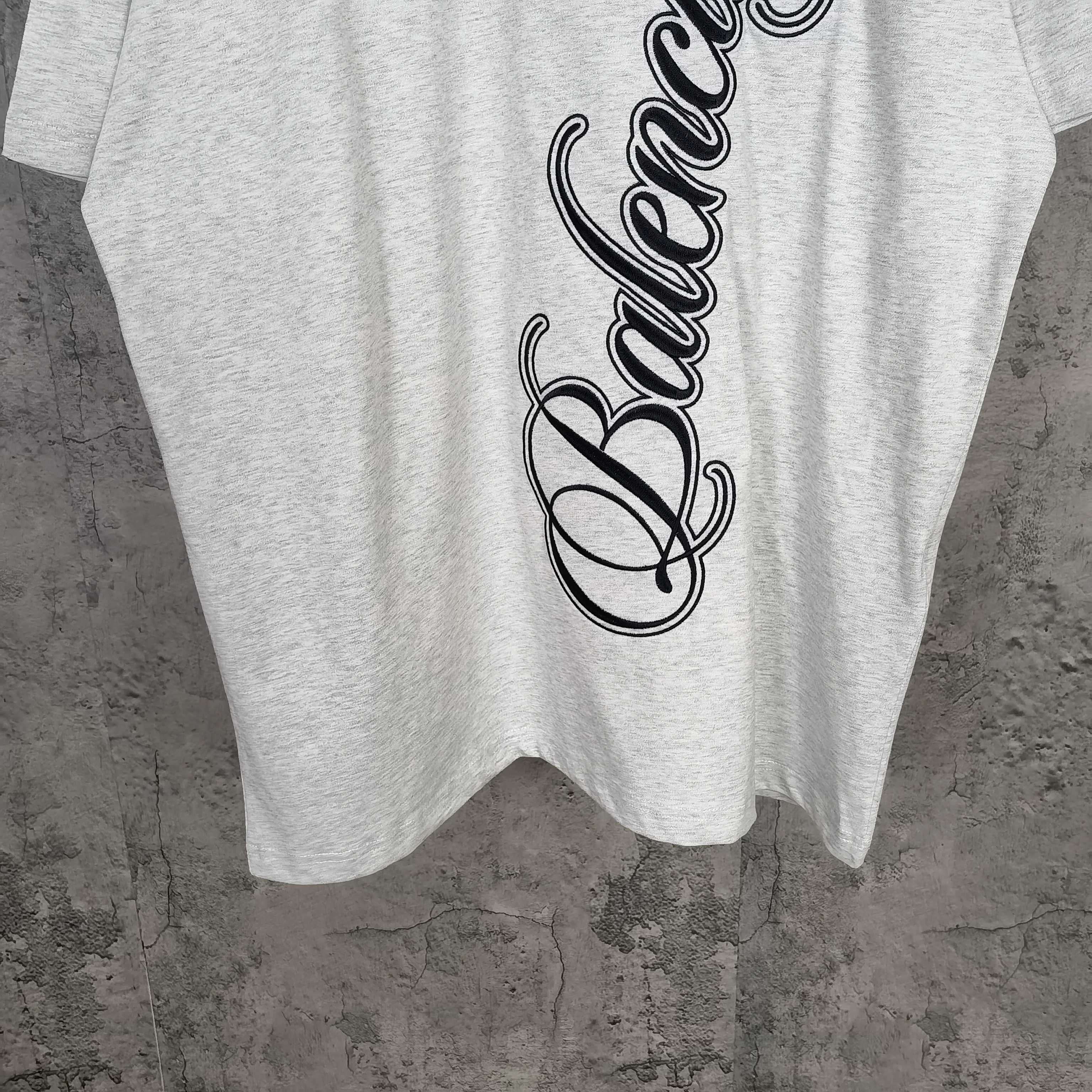 Balenciaga script logo T-shirt detail on light gray fabric