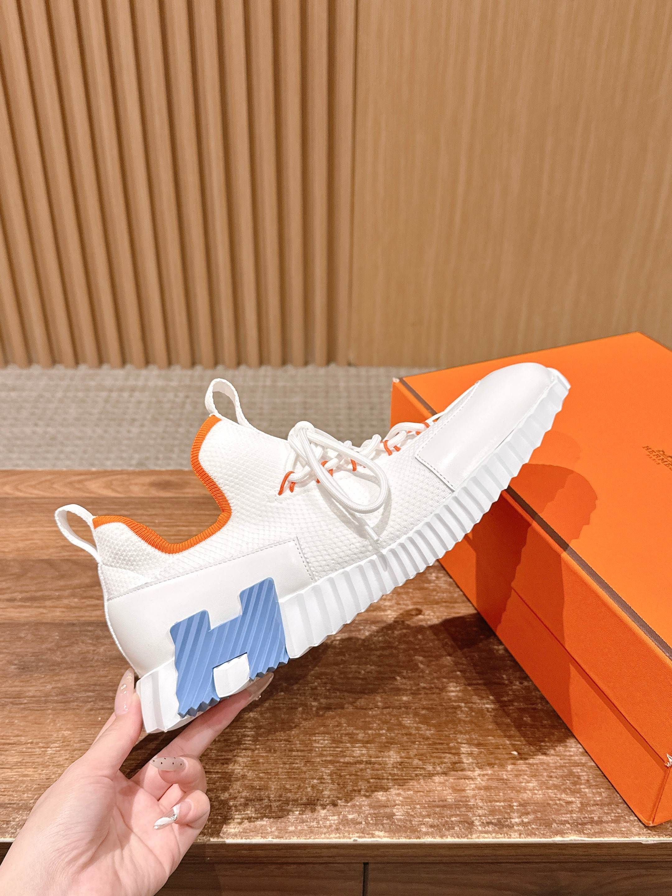 Hermes unisex sneakers, white mesh with blue logo panel and orange laces.