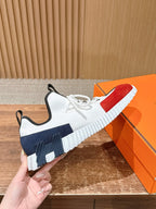 Unisex sneaker detail: white upper with red and navy sections, thick sole, lace-up