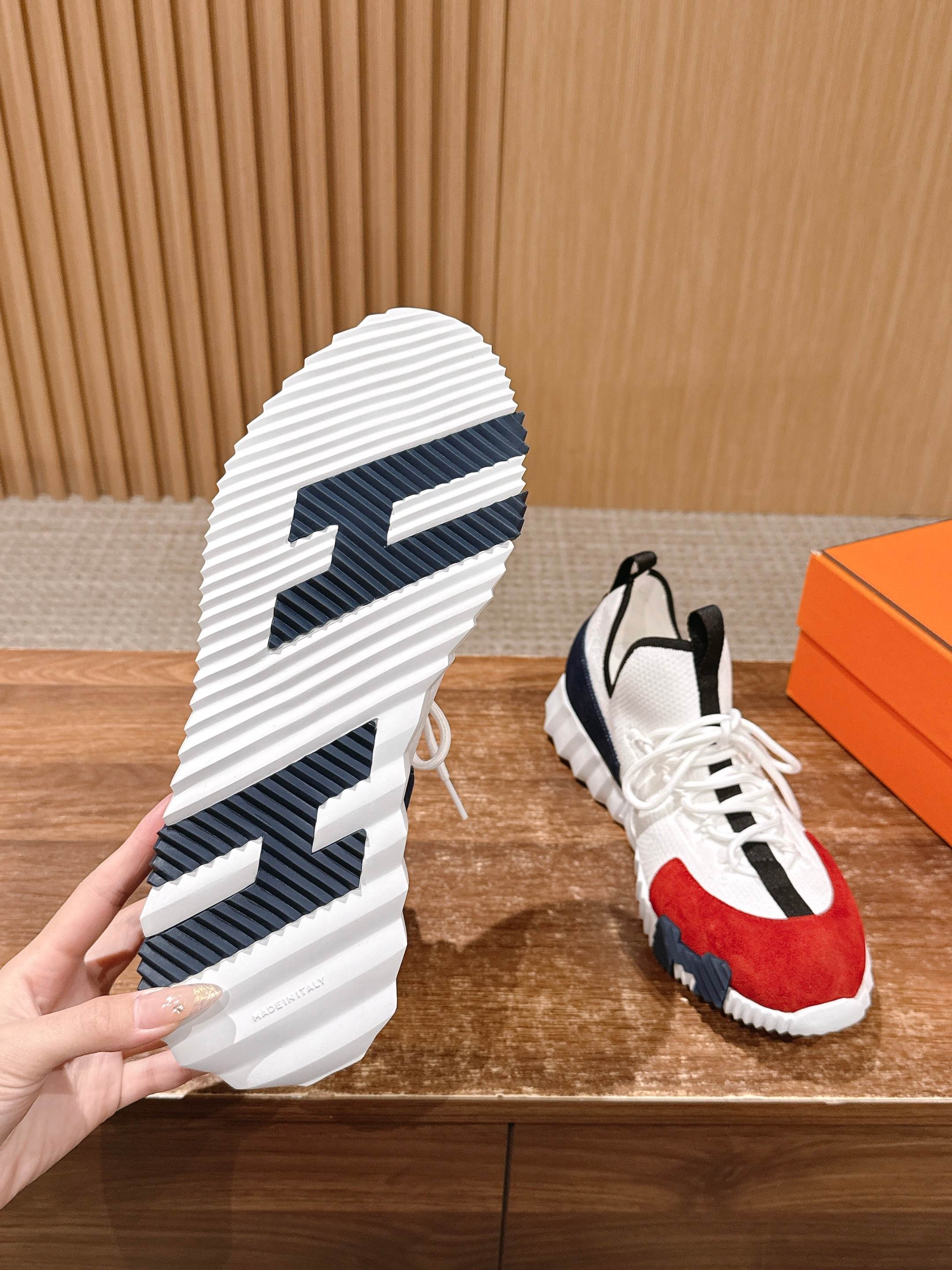 Unisex sneaker outsole view with blue tread lines, paired with red-and-navy upper shoe