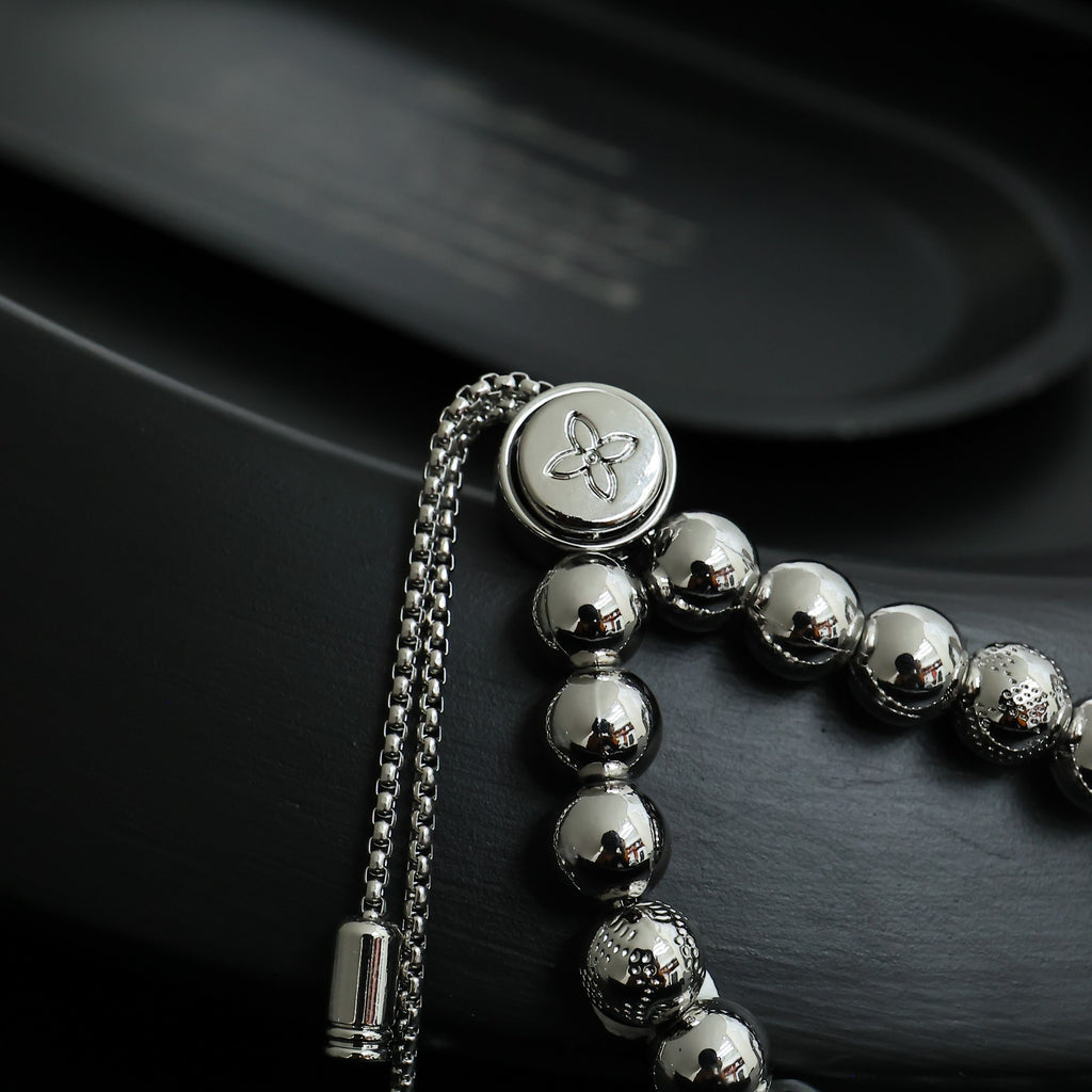 Louis Vuitton beaded bracelet with round silver beads and small flower emblem medallion