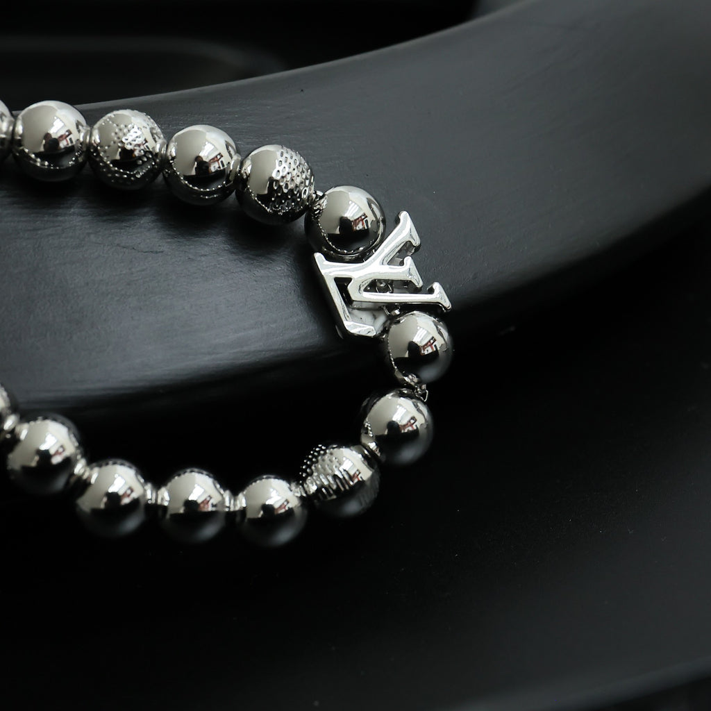 Louis Vuitton beaded bracelet with round silver beads and dangling LV logo charm