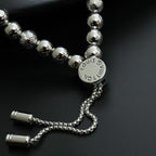 Louis Vuitton beaded bracelet with round silver beads, engraved medallion, and chain tassels