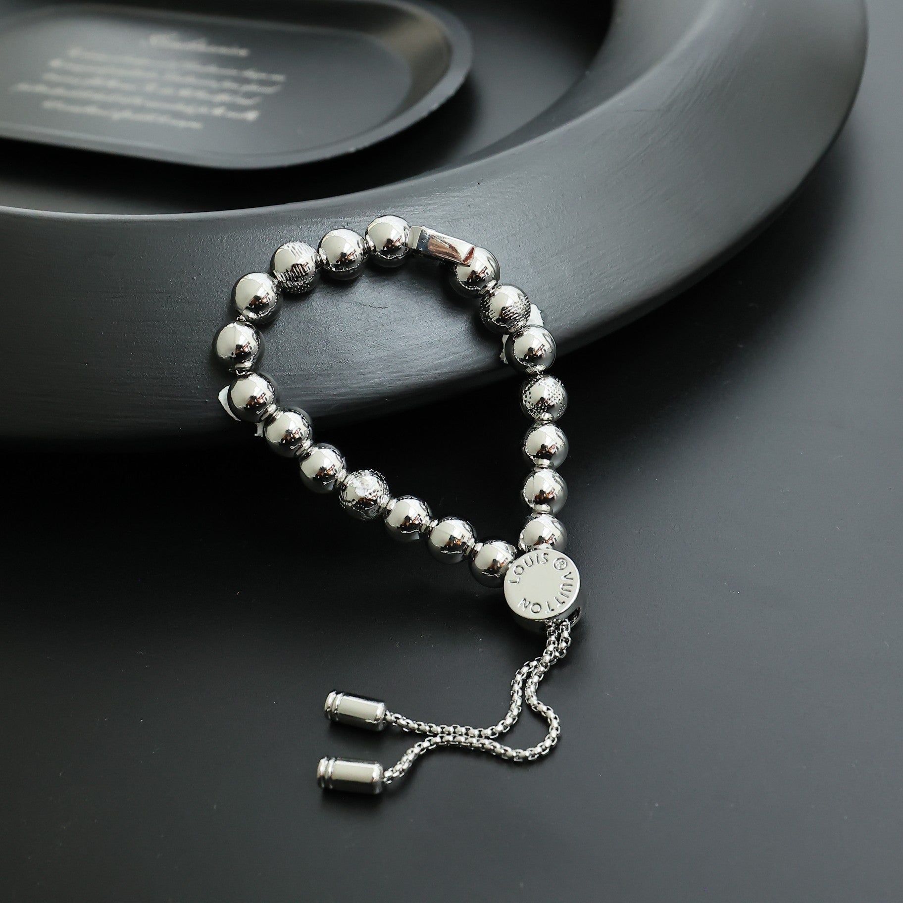 Louis Vuitton beaded bracelet with round silver beads and small engraved charm plate