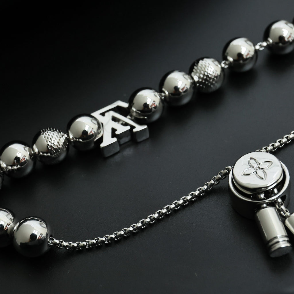 Louis Vuitton beaded necklace with round silver beads, LV charm, and flower medallion