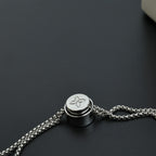 Beaded necklace clasp with round silver-toned cap and chain link attachment