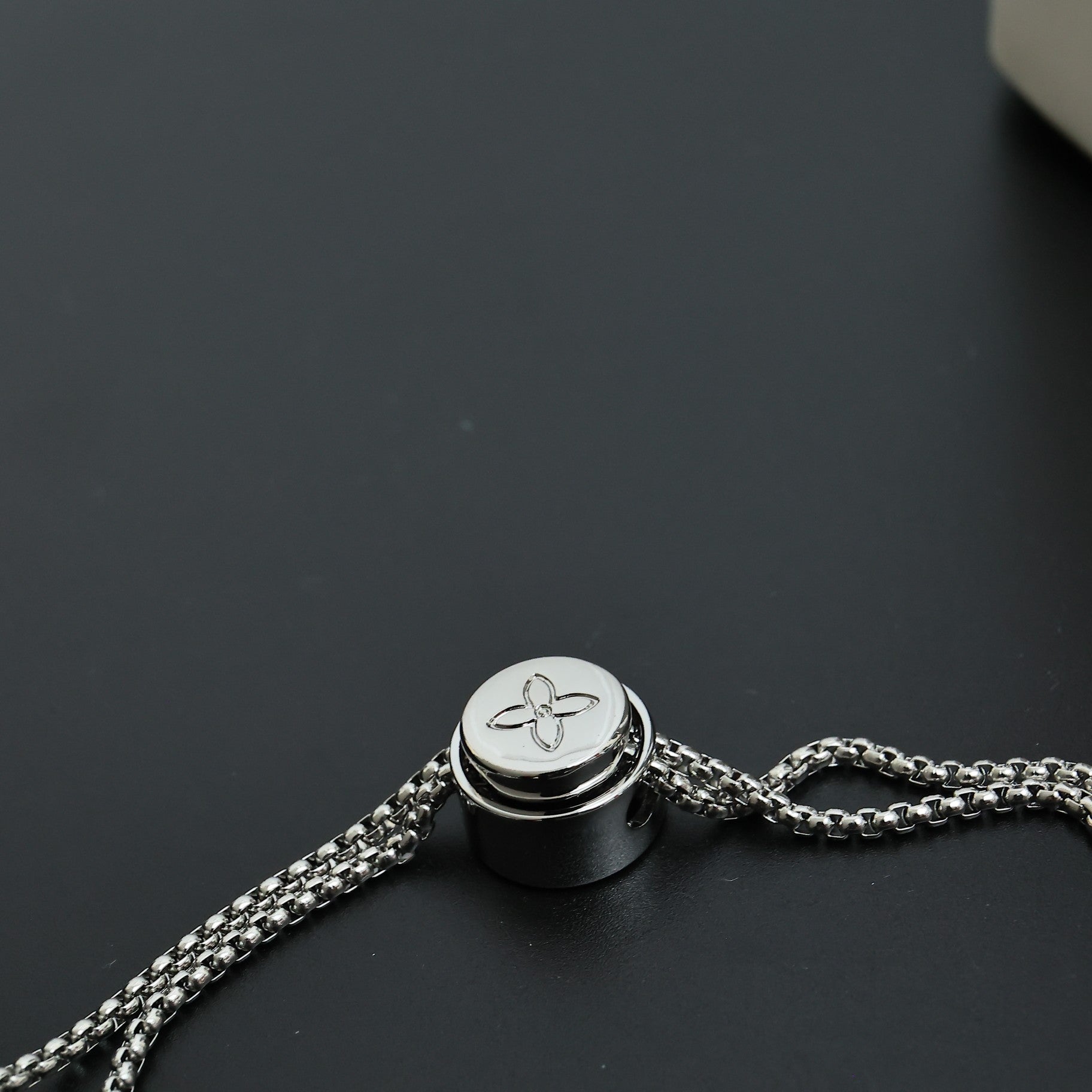 Beaded necklace clasp with round silver-toned cap and chain link attachment
