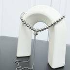 Beaded necklace draped on a white display stand with silver-toned bead chain