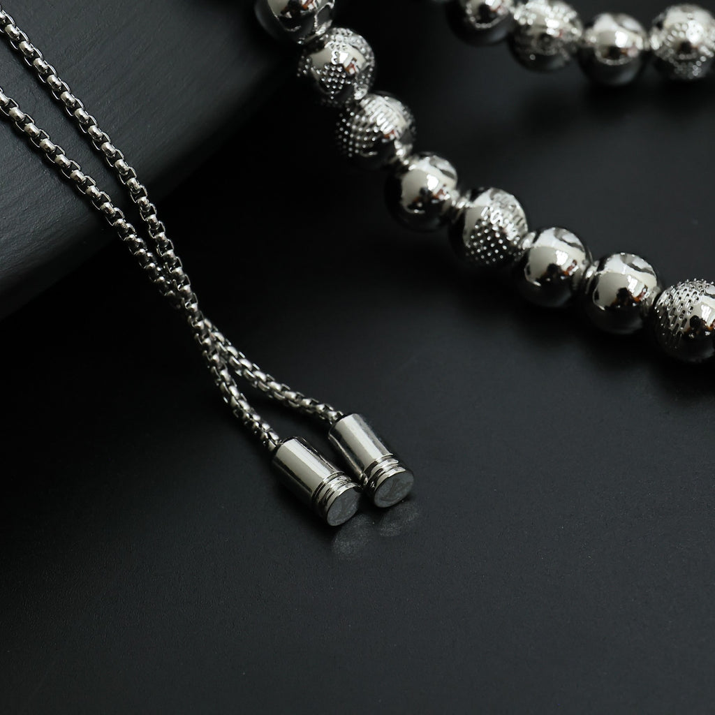 Beaded necklace close-up with silver-toned chain ends and small cylindrical tips
