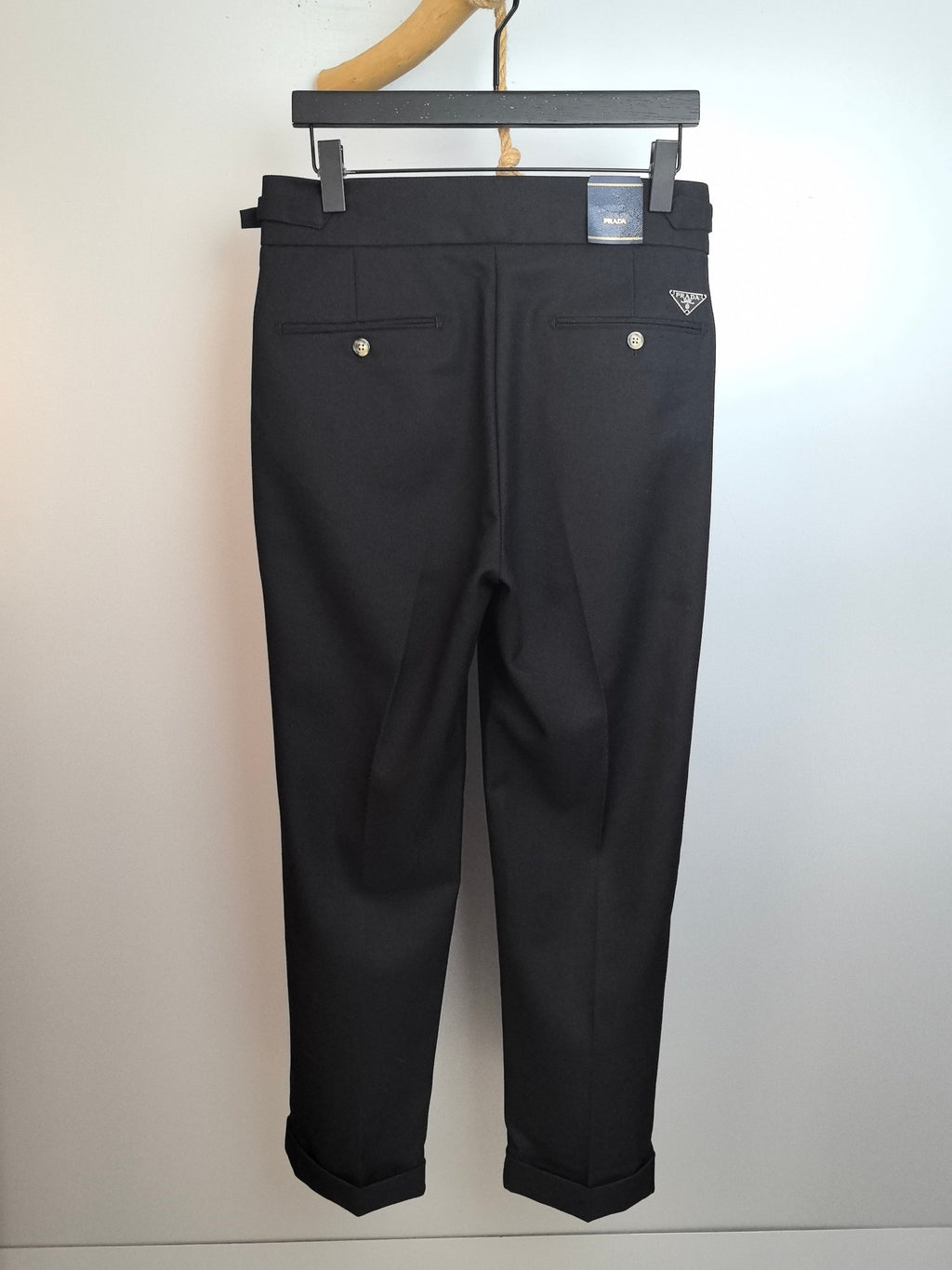 Dark trousers with belt loops, button-front closure, and front pockets
