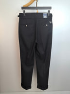 Dark trousers with belt loops, button-front closure, and front pockets