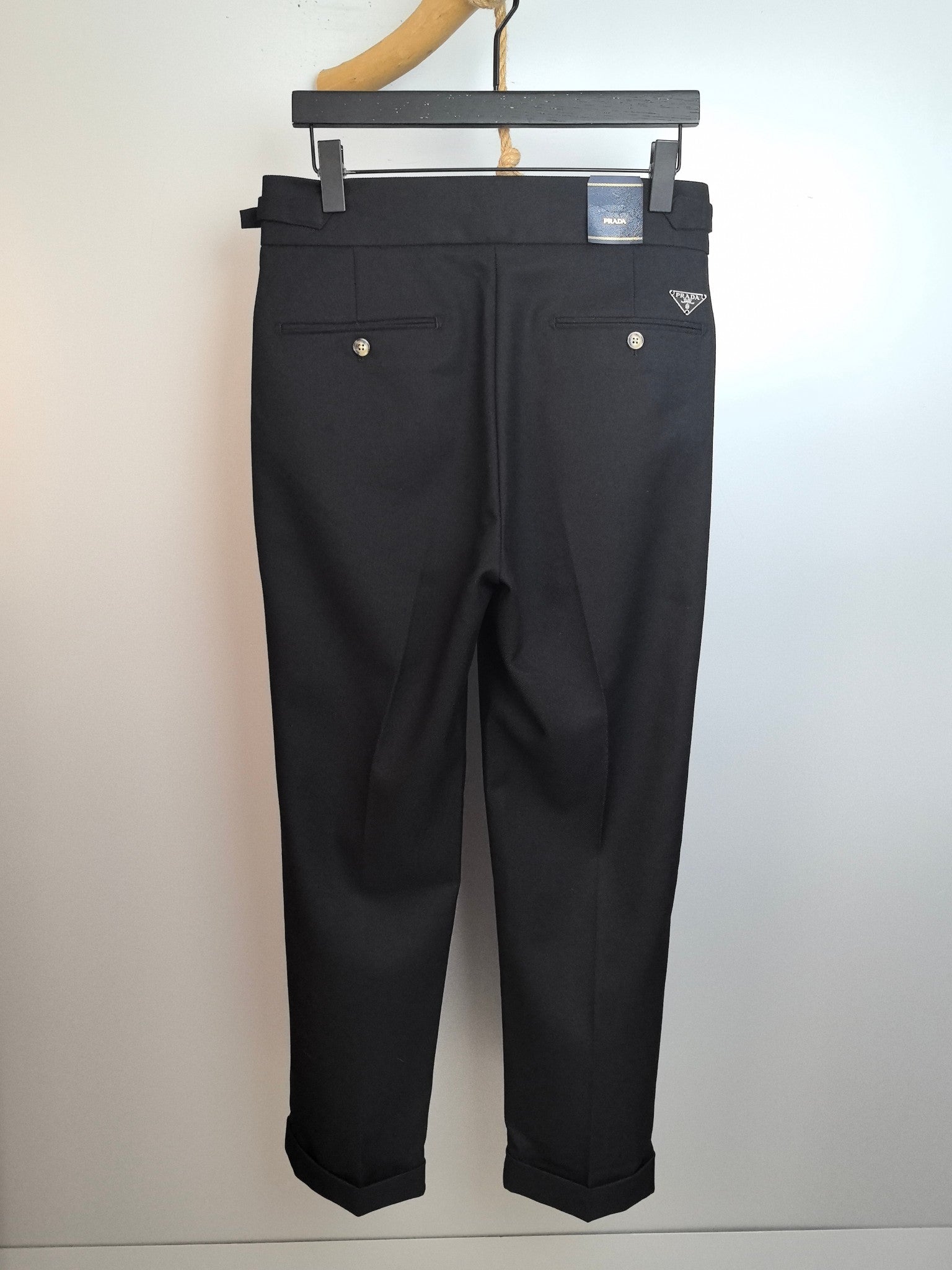 Dark trousers with belt loops, button-front closure, and front pockets