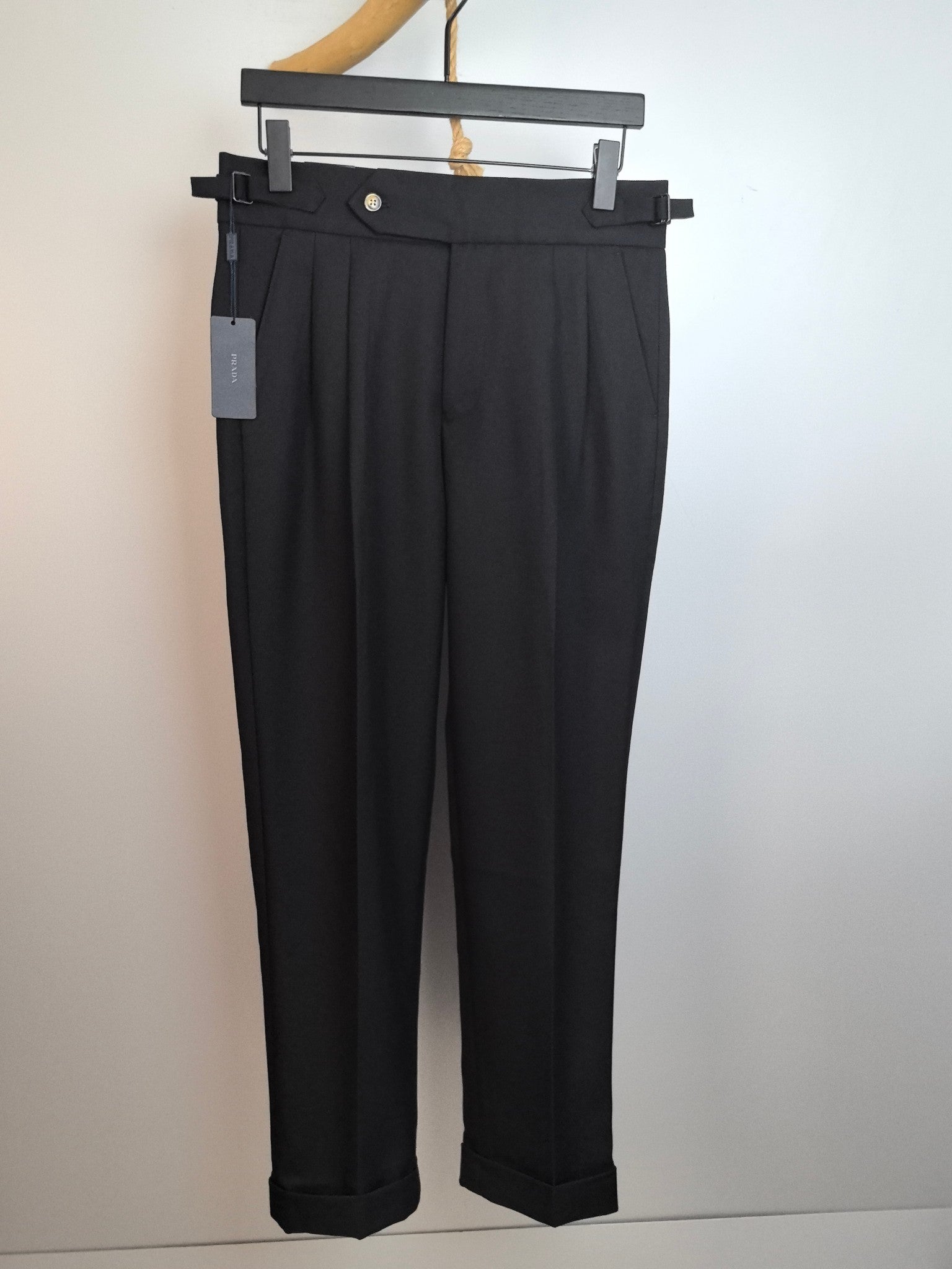 Black dress pants with waistband, front pleats, and concealed button closure