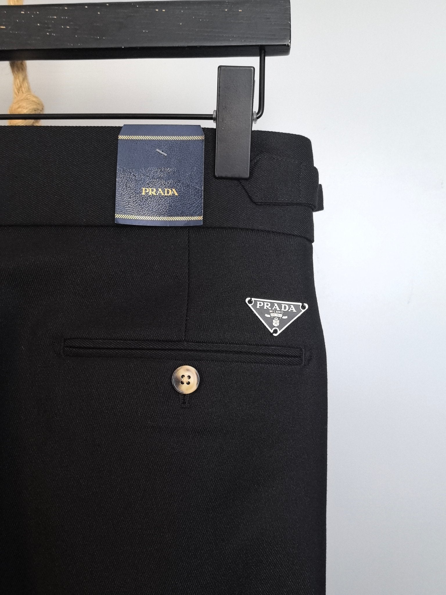 Black trousers with Prada logo patch and belt loop near waistband
