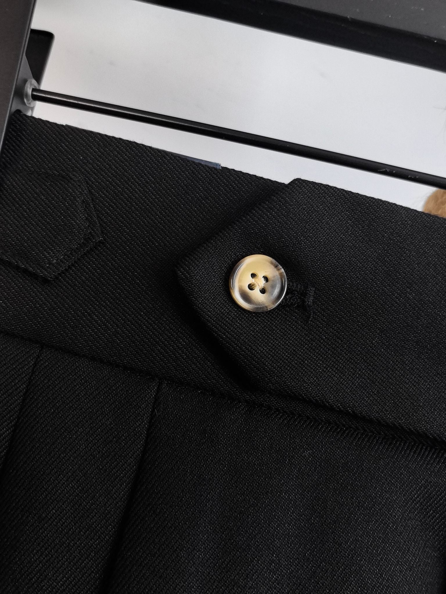 Black pants with front button and tailored pocket flap detail