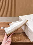 White leather sneakers with lace-up closure and beige rubber sole