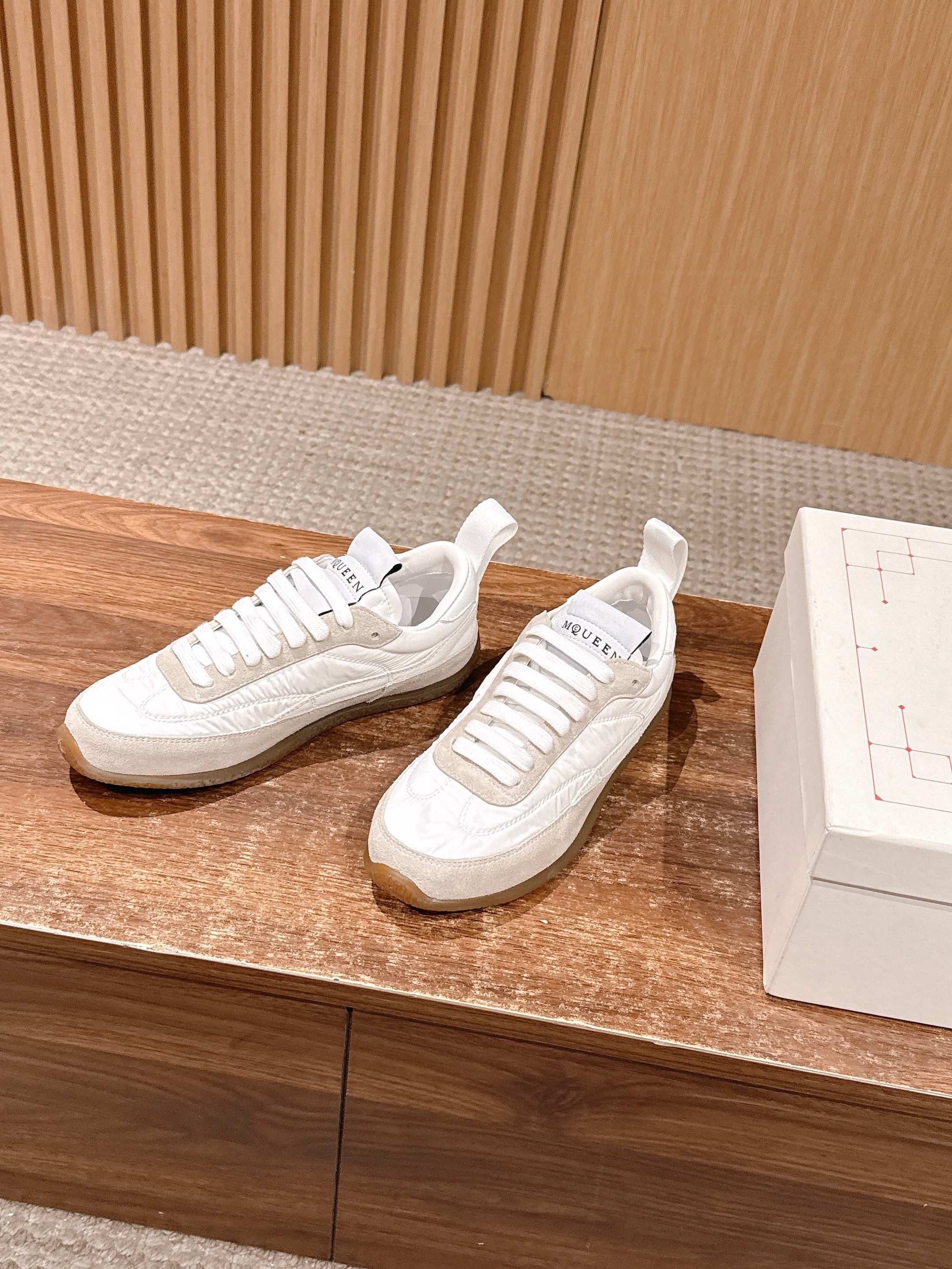 White lace-up sneakers with textured side panel and beige rubber sole