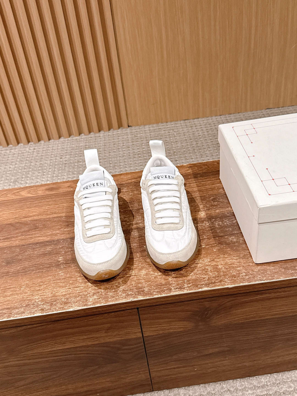 Pair of white lace-up sneakers with logo label on the tongue