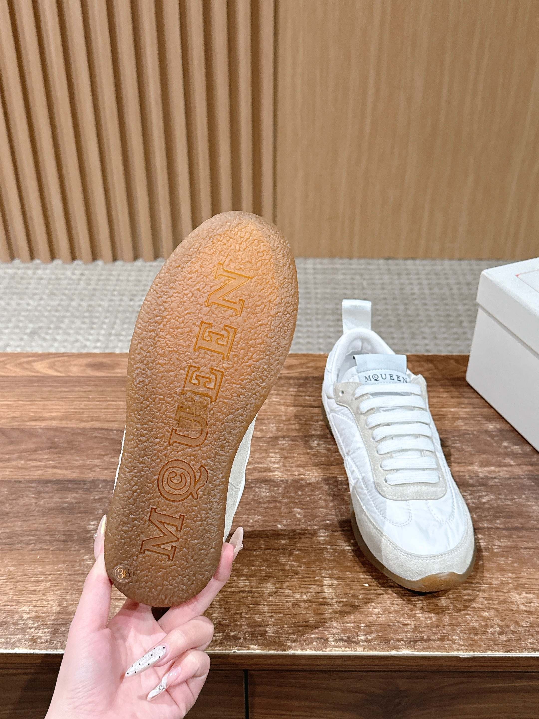 White sneakers showing textured logo on underside of the outsole