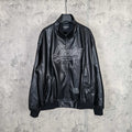 Black leather jacket with stand collar, front zip, and white “Luxury” graphic