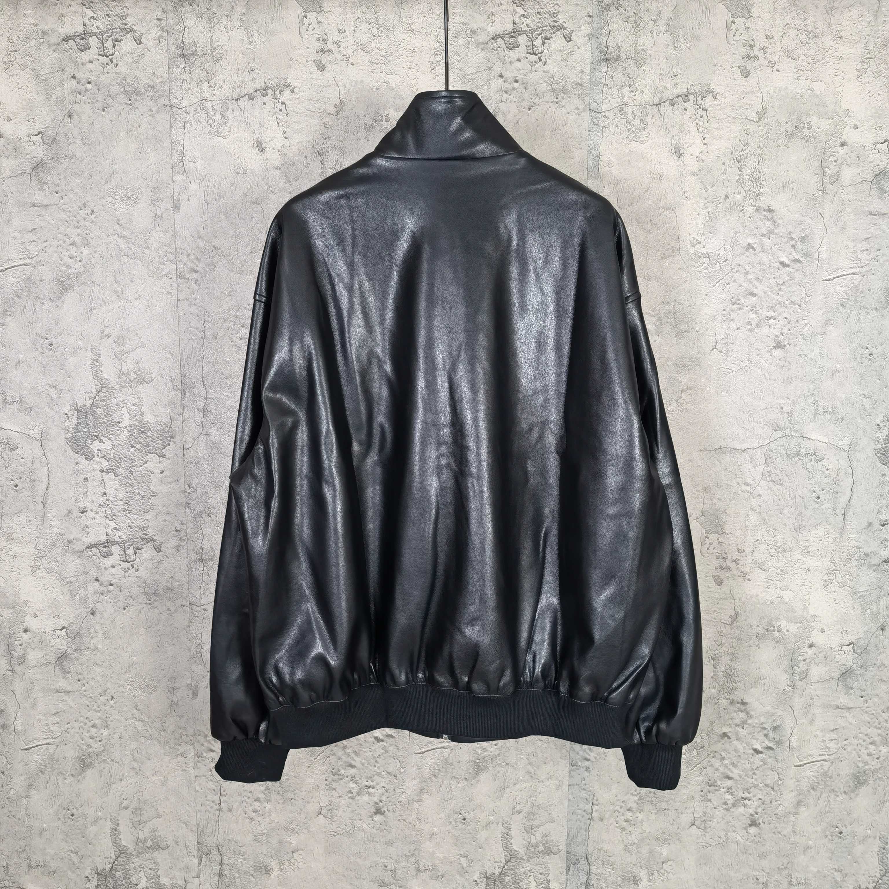 Black leather jacket back view with ribbed hem and sleeves