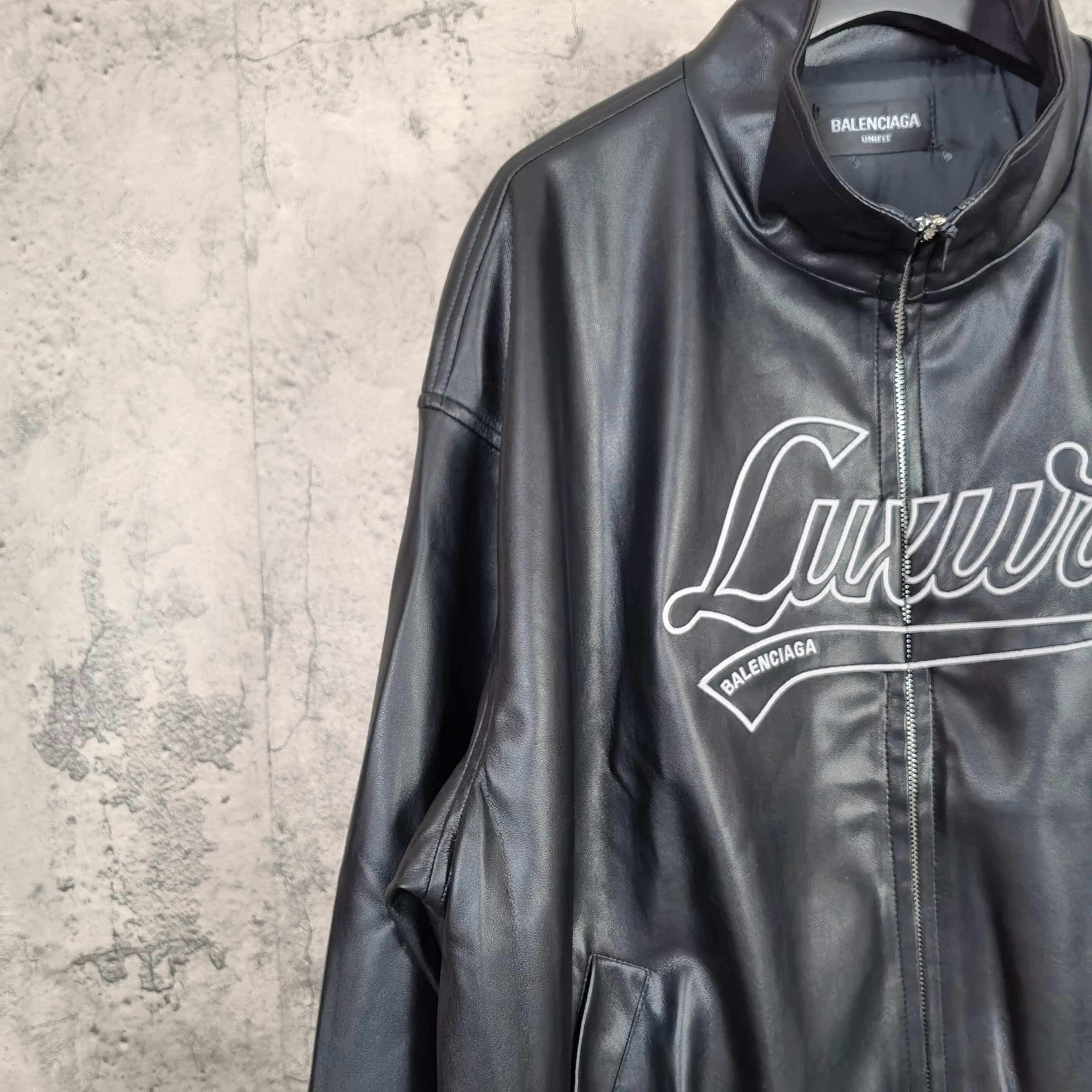 Black leather jacket front close-up of stand collar and “Luxury” graphic