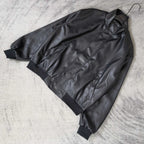 Balenciaga dark leather jacket laid flat, showing zip front and seam details