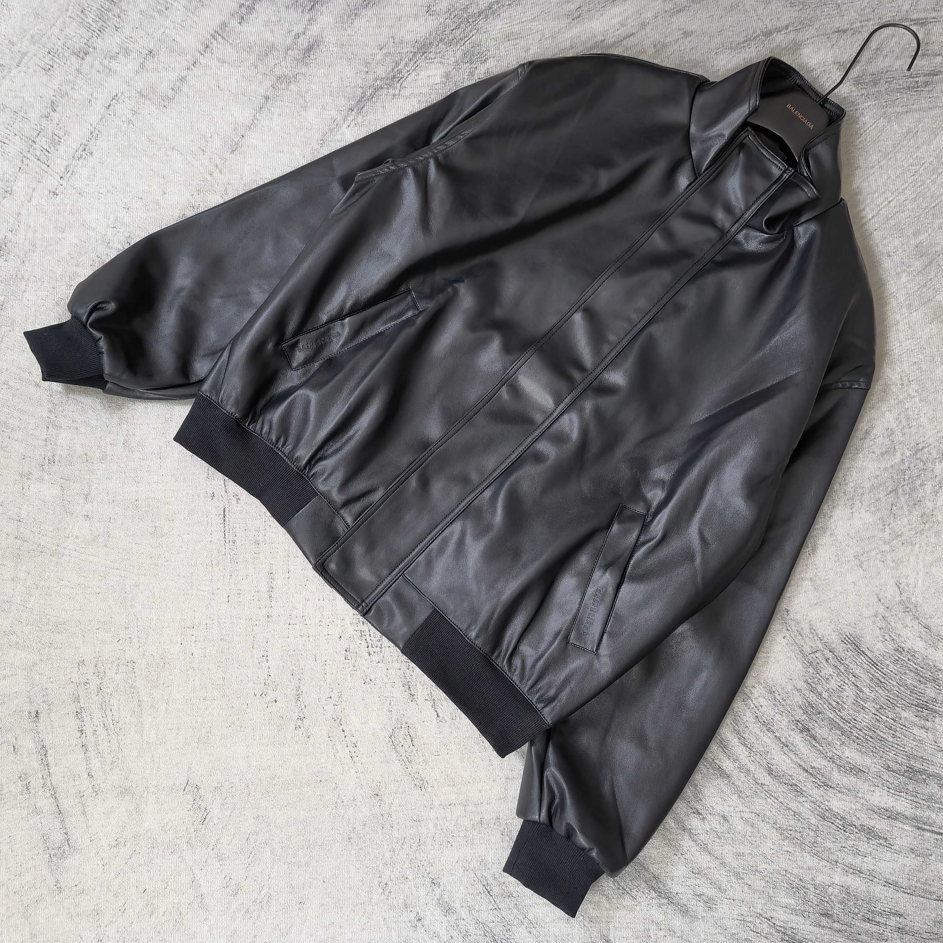 Balenciaga dark leather jacket laid flat, showing zip front and seam details