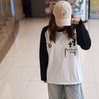 Long-sleeve raglan shirt with black sleeves, white body, and gothic chest graphic
