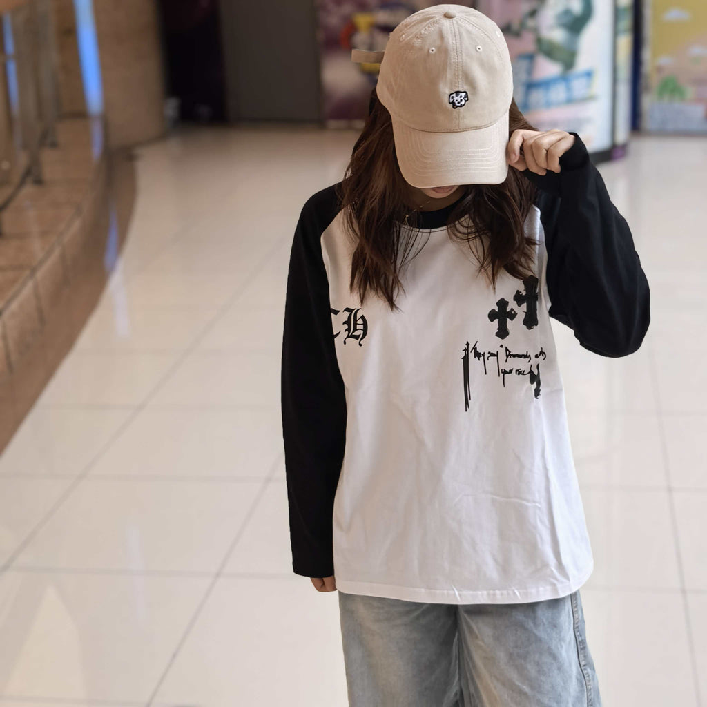 Raglan long-sleeve T-shirt on model, white front with black sleeves and cross graphic