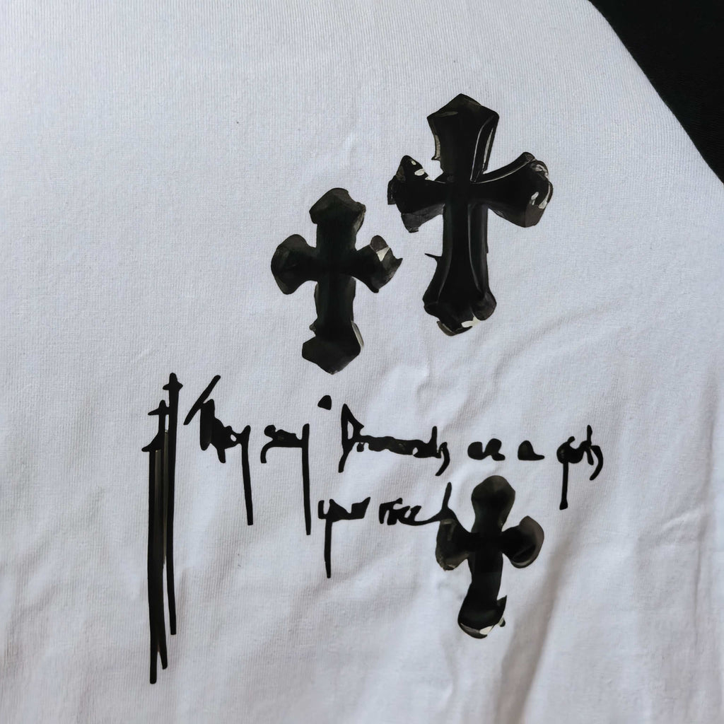 Close-up of white long-sleeve shirt with black cross and gothic text print
