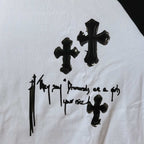 Close-up of white T-shirt graphic print with black crosses and symbol-like lettering