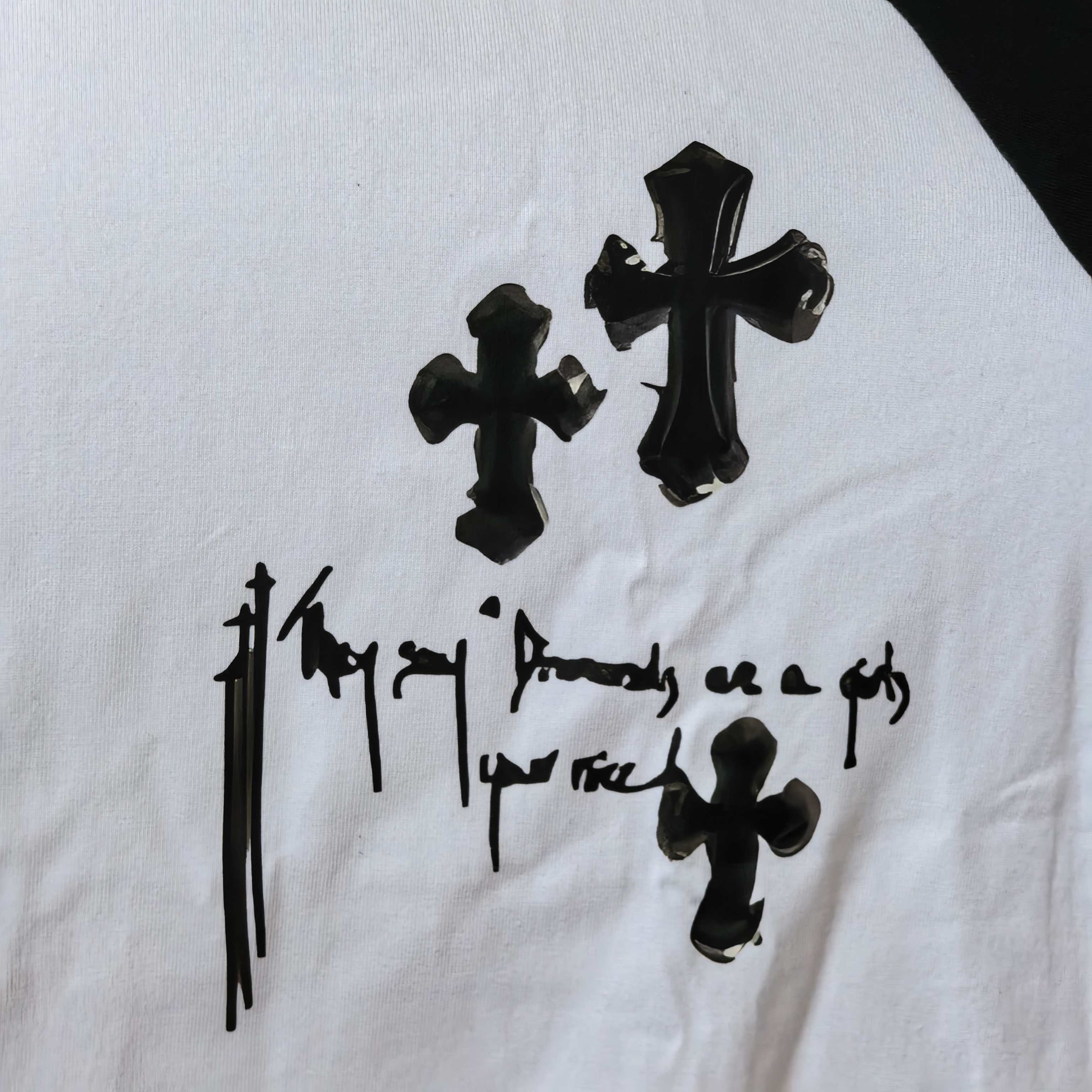 Close-up of white T-shirt graphic print with black crosses and symbol-like lettering