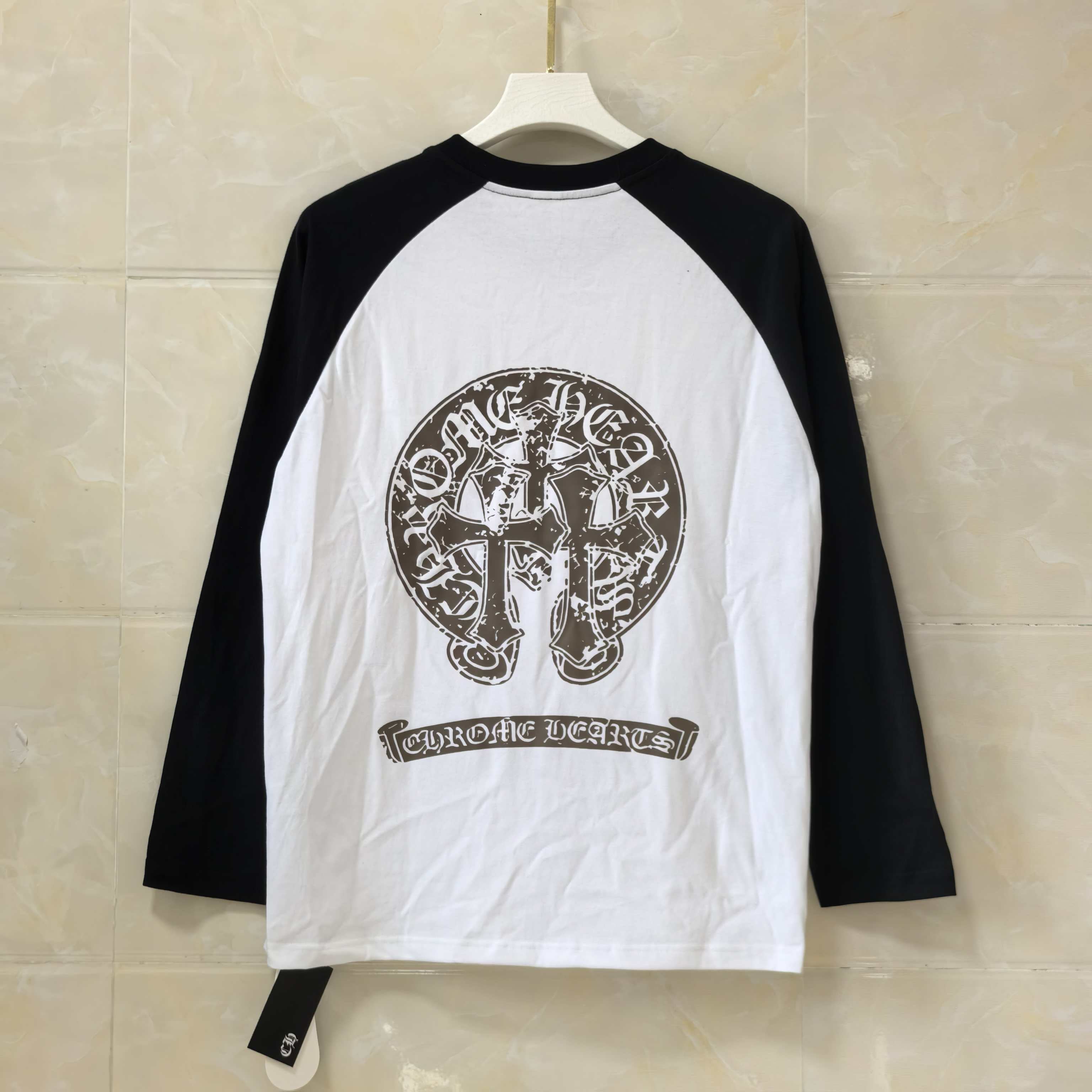 Black-and-white long-sleeve raglan shirt with round neck and front crest graphic