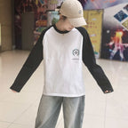 Long-sleeve raglan shirt, white body with black sleeves and small chest logo