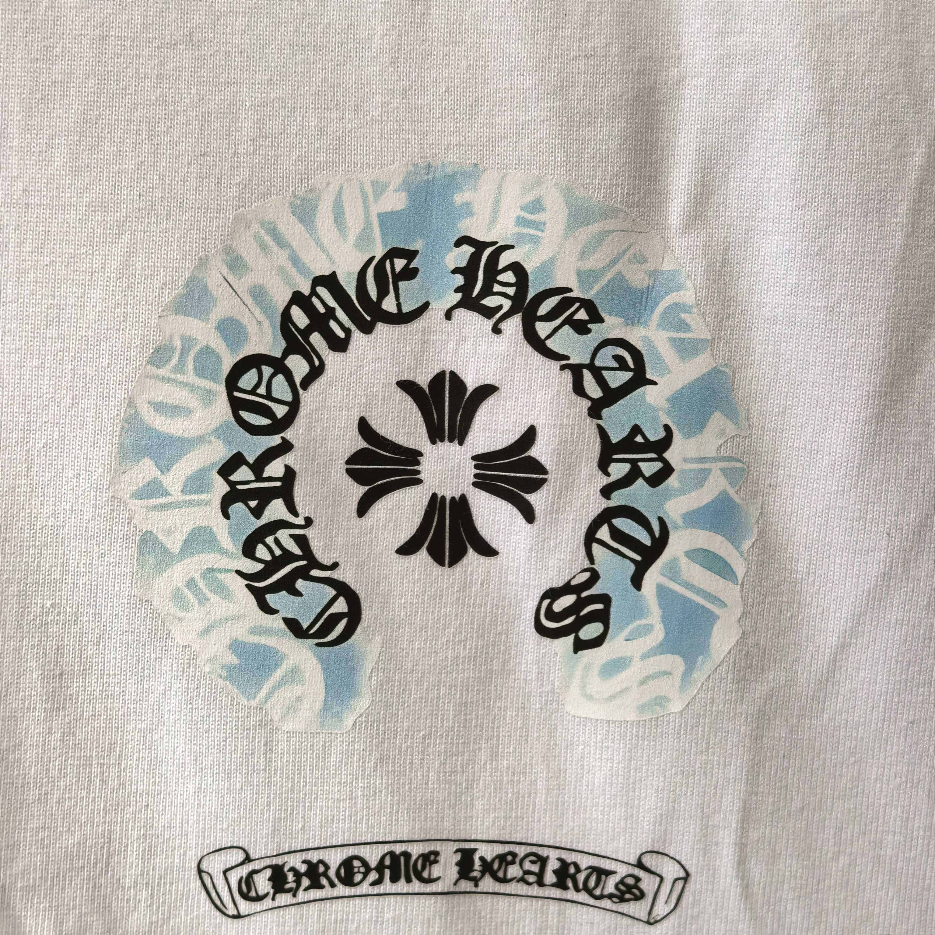 Close-up of round graphic and text print on white long-sleeve shirt