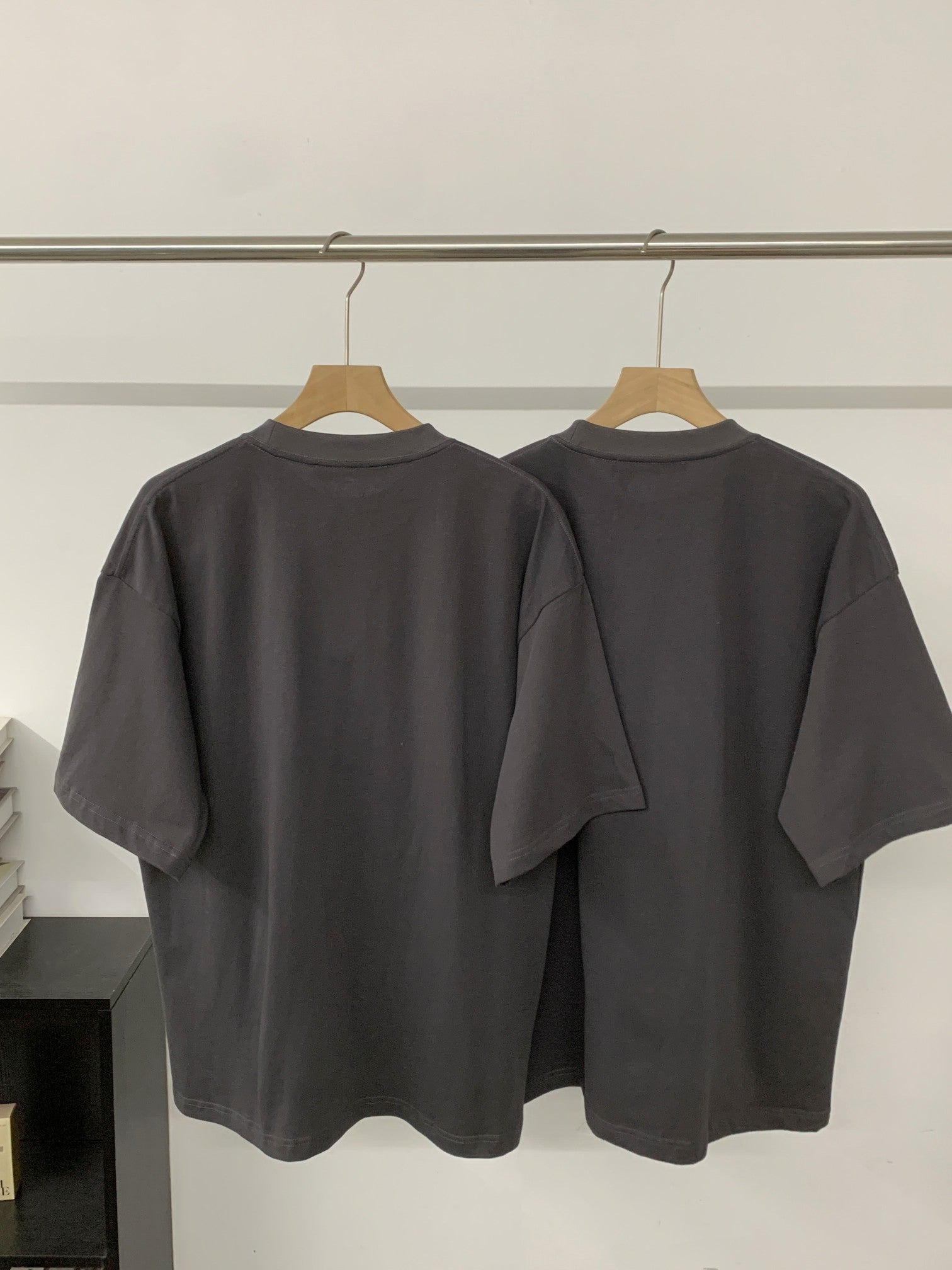 Black short-sleeve T-shirt, back view with crew neck and smooth hem