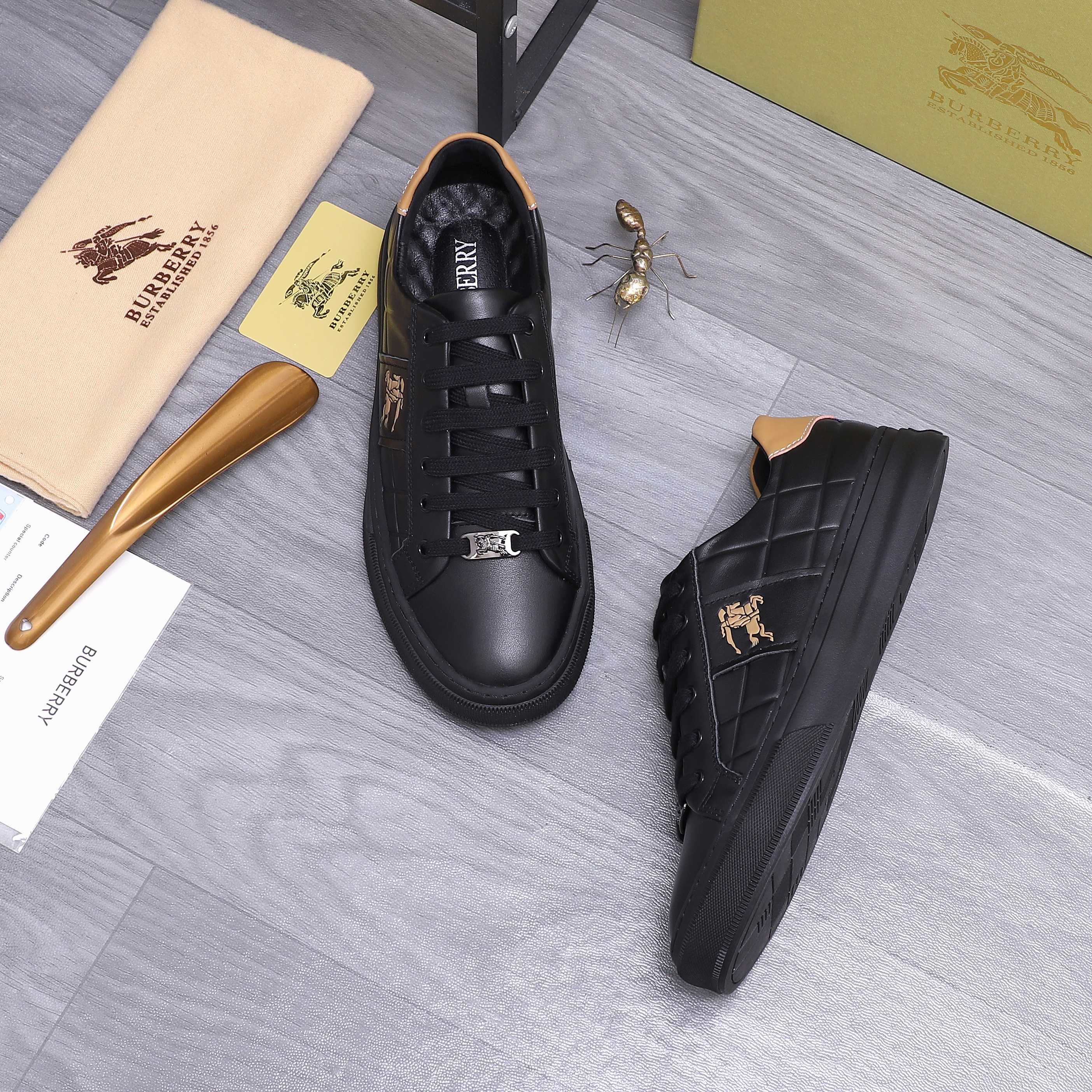 Black Burberry lace-up sneakers with horse logo on the tongue and side emblem.