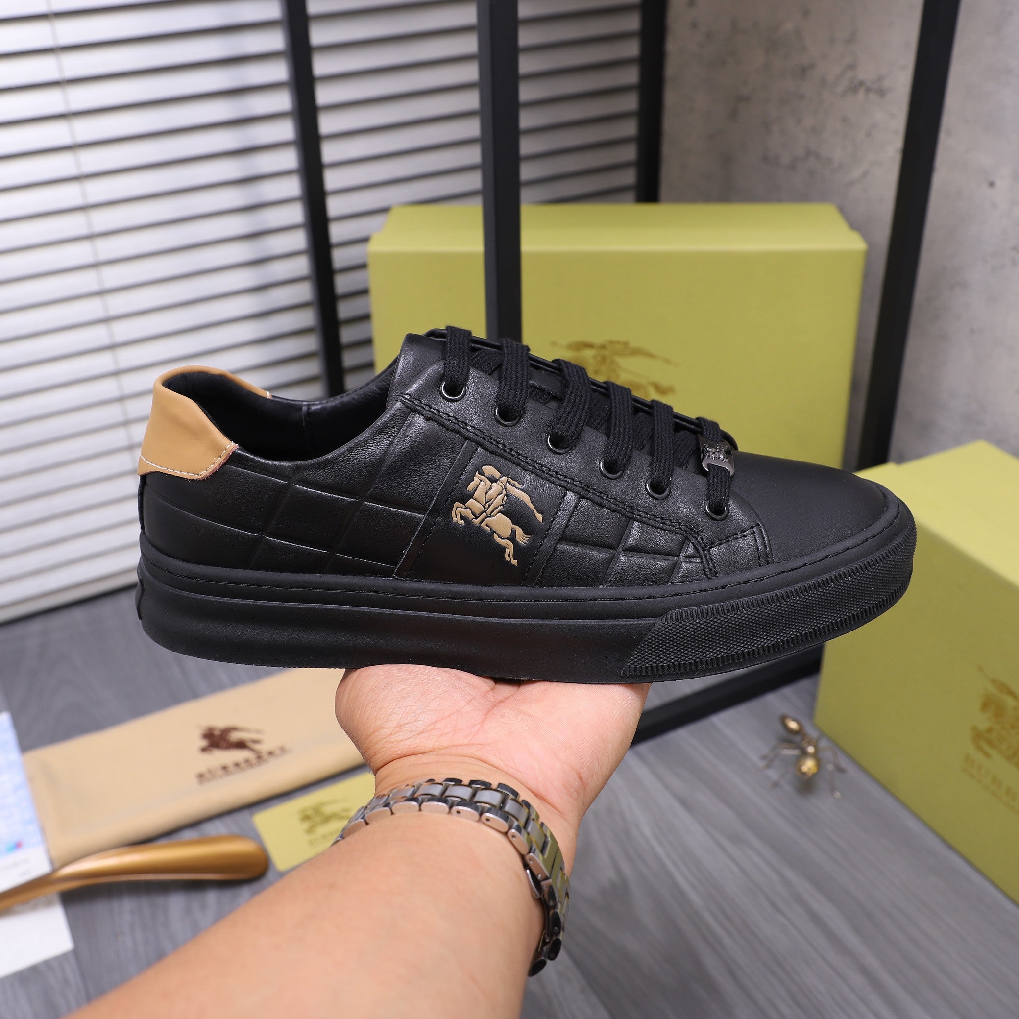 Black Burberry lace-up sneaker with quilted pattern, tan collar, and horse emblem.